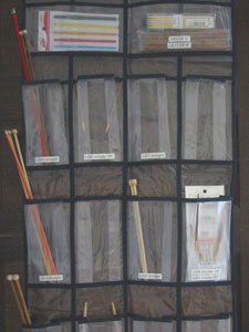 Knitting supplies organized into hanging pockets