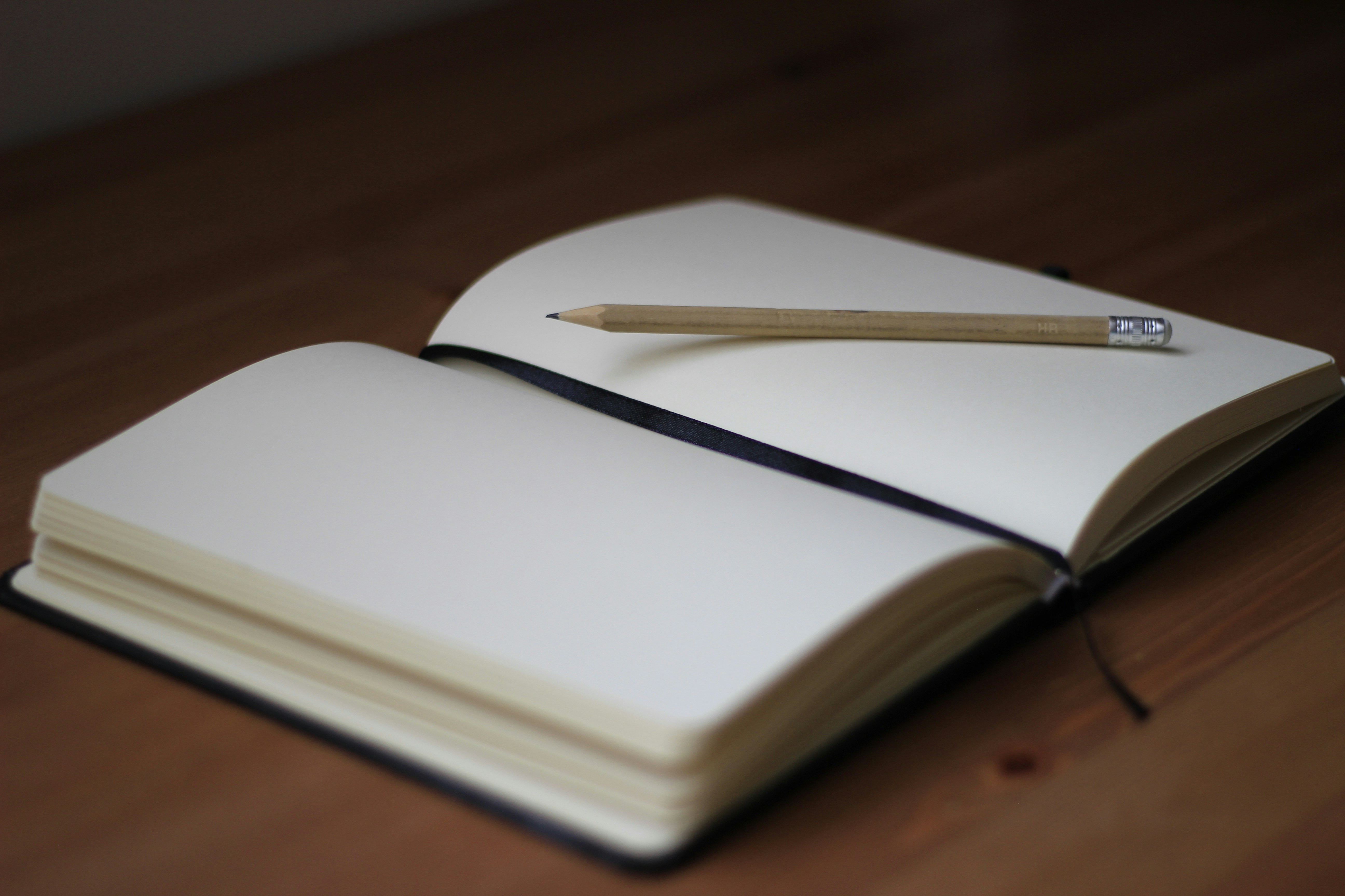 Open notebook with a pencil on a desk